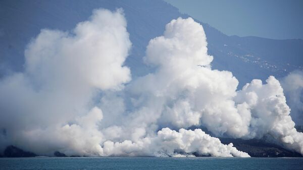 El humo se eleva mientras la lava fluye hacia el mar tras la erupción de un volcán, La Palma, España, 6 de octubre de 2021 - Sputnik Mundo