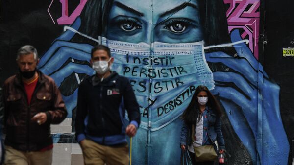 Colombianos cerca de un mural que representa a una mujer con una mascarilla en Bogotá  - Sputnik Mundo