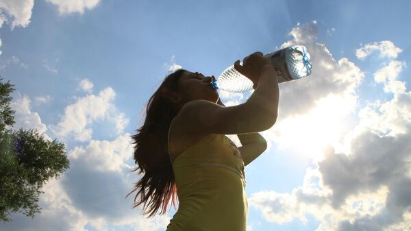 Una mujer tomando agua - Sputnik Mundo