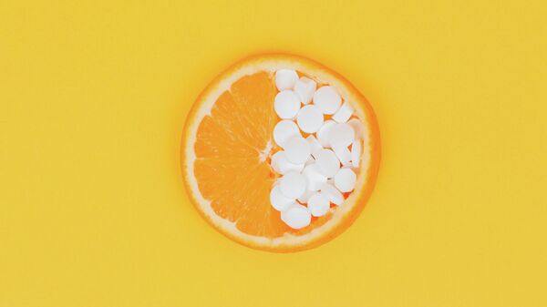 Un pedazo de naranja con unas pastillas - Sputnik Mundo