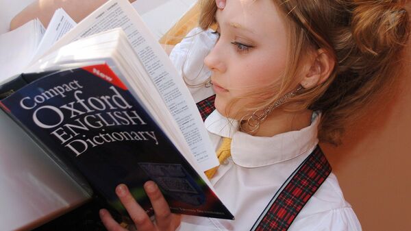 Una muchacha lee un diccionario Oxford - Sputnik Mundo