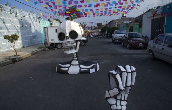 En estos días, se suelen adornar las casas con esqueletos artificiales y otros atributos por el Día de Muertos. La gente se divierte, canta y baila. - Sputnik Mundo