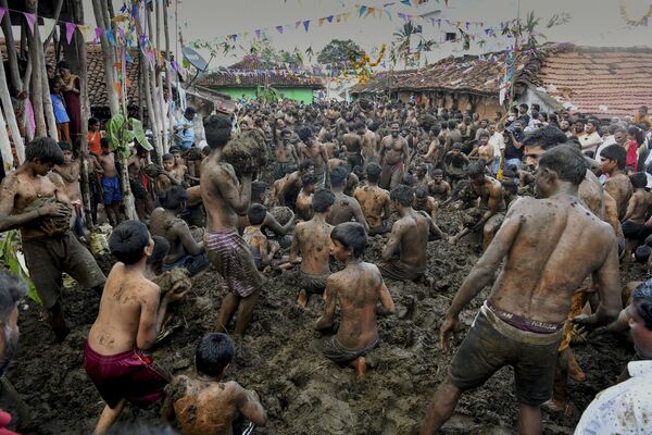 La gente se arroja y se unta con estiércol de vaca durante el festival anual Gore Habba, en la aldea de Gumatapura (la India), el 6 de noviembre de 2021. - Sputnik Mundo