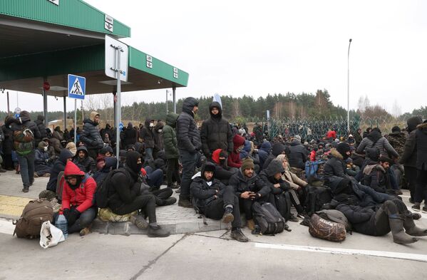 La columna de migrantes, encabezada por mujeres con niños pequeños, se extendía por un kilómetro. Fueron seguidas y vigiladas por las fuerzas de seguridad bielorrusas. - Sputnik Mundo