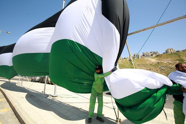 Unos trabajadores del municipio de Amán (Jordania) instalan una bandera jordana de 2.132 metros de largo con el objetivo de romper el récord mundial de la bandera más larga del mundo el 15 de abril de 2021. - Sputnik Mundo