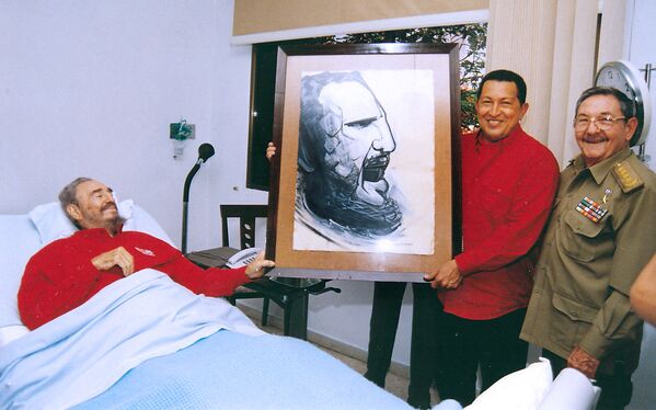 El presidente venezolano Hugo Chávez (centro) sostiene un retrato de Fidel Castro, realizado por el famoso muralista mexicano David Alfaro Siqueiros durante una visita al hospital donde el revolucionario cubano se recuperaba de una cirugía, el 13 de agosto de 2006. - Sputnik Mundo