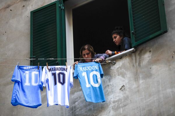 Una mujer cuelga camisetas de Maradona en una línea de secado, en el popular barrio Quartieri Spagnoli, en Nápoles (Italia), el 26 de noviembre de 2020. - Sputnik Mundo