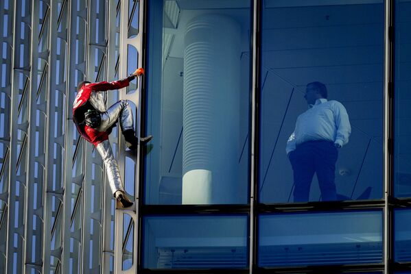 El escalador urbano francés Alain Robert sube a la cima del rascacielos Skyper en el centro de Fráncfort (Alemania). - Sputnik Mundo