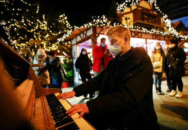 Un pianista en un mercado navideño de Colonia, Alemania. - Sputnik Mundo