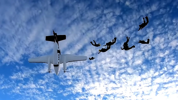 Un avión casi arrolla a un grupo de paracaidistas poco después de saltar | Video - Sputnik Mundo
