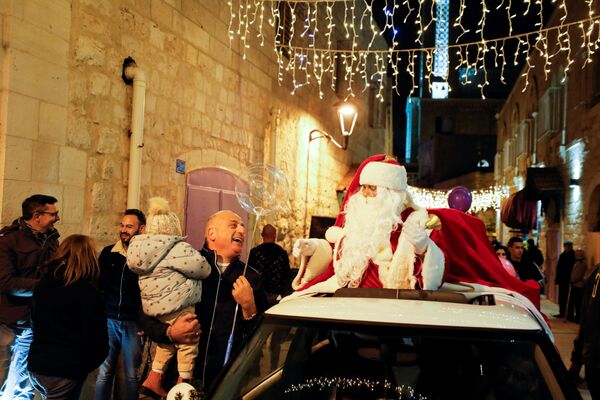 En Belén, Cisjordania, los palestinos celebraron el 2 de diciembre un acto festivo con Papá Noel, interpretado por un residente local. Hoy en día, en esta ciudad de 25.000 habitantes sólo uno de cada seis profesa el cristianismo, pero según las leyes locales sólo un cristiano puede ser alcalde de la histórica capital de la Navidad. - Sputnik Mundo