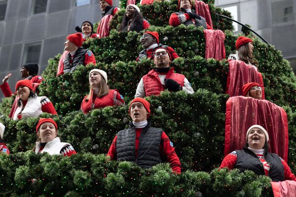 Un árbol de Navidad de la ciudad de Nueva York, en Estados Unidos. Una plataforma con un improvisado árbol compuesto por los miembros del coro navideño de empleados de Macy&#x27;s, la cadena de tiendas más antigua de Estados Unidos, sigue cada año el recorrido del desfile del Día de Acción de Gracias en el centro de Manhattan. - Sputnik Mundo