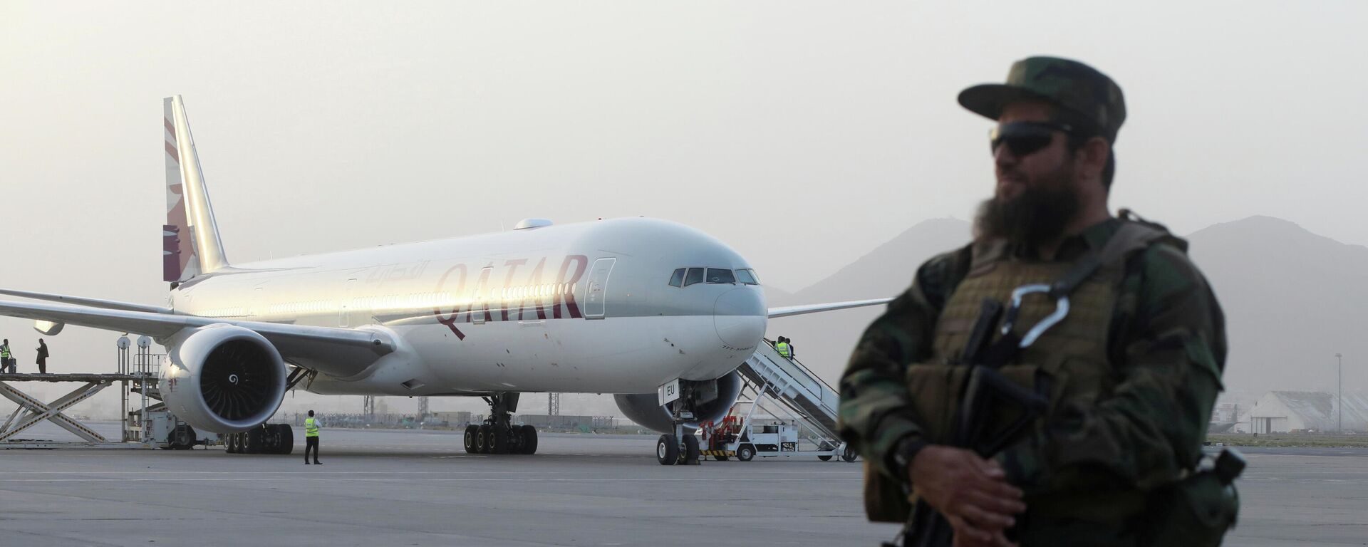 Un miembro de las fuerzas de seguridad talibanes monta guardia frente a un avión de Qatar Airways, en el Aeropuerto Internacional de Kabul, Afganistán, el 10 de septiembre de 2021 - Sputnik Mundo, 1920, 17.12.2021