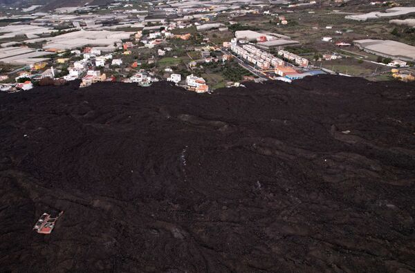 Una vista aérea de las cenizas volcánicas cerca de una zona residencial en la isla de La Palma. - Sputnik Mundo