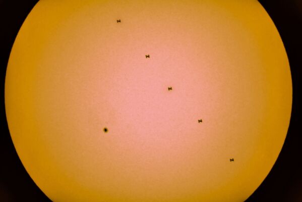 Esta composición de cinco fotografías muestra una mancha solar y las siluetas de la EEI contra el disco solar, el 19 de junio. - Sputnik Mundo