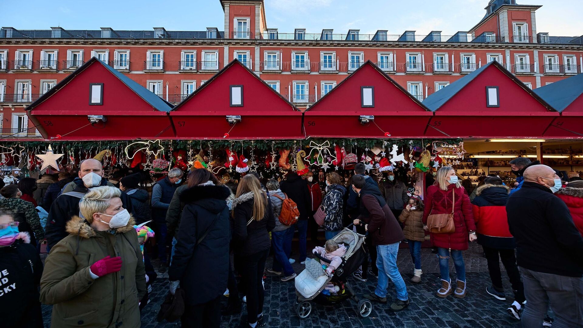 Un grupo de personas asiste al mercadillo navideño instalado en la madrileña plaza mayor - Sputnik Mundo, 1920, 27.12.2021