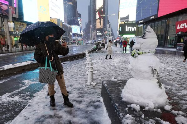 Un hombre toma fotos de un muñeco de nieve en Nueva York, EEUU, el 7 de enero de 2022. - Sputnik Mundo