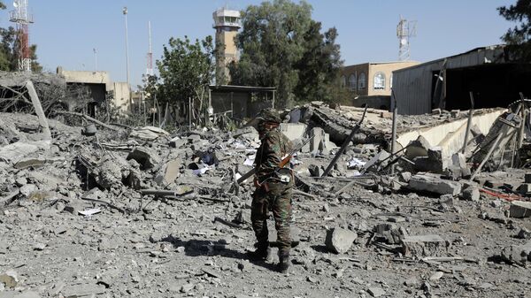 Un policía camina sobre los escombros de un edificio destruido por los ataques aéreos liderados por Arabia Saudita en Yemen - Sputnik Mundo