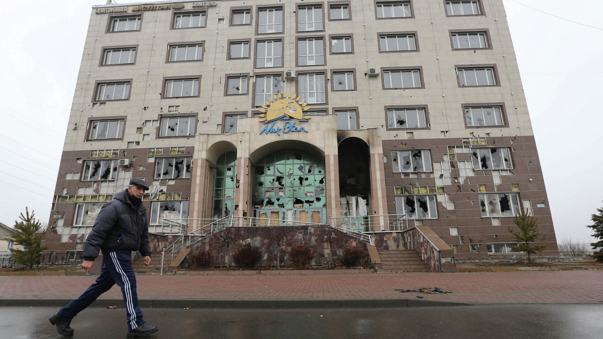Un hombre pasa frente al edificio de oficinas del partido gobernante Nur Otan, dañado durante las protestas masivas, en Almaty, Kazajistán, el 8 de enero de 2022 - Sputnik Mundo, 1920, 09.01.2022