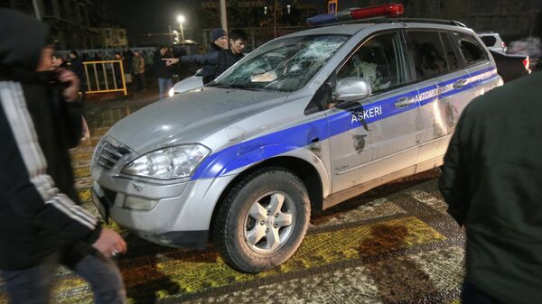 Los manifestantes rodean un coche de Policía dañado durante una protesta contra el aumento del costo del gas licuado, en Almaty, Kazajistán, el 4 de enero de 2022 - Sputnik Mundo