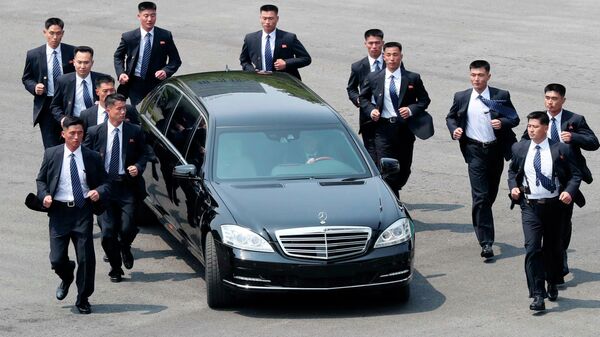 Unos agentes de seguridad  norcoreanos acompañan el automóvil que transporta al líder norcoreano Kim Jong-un tras un encuentro con el presidente surcoreano Moon Jae-in. - Sputnik Mundo