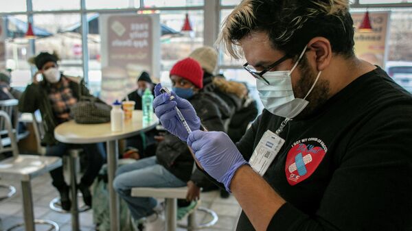 La gente se vacuna contra el COVID-19 y reciben dosis de refuerzo en Chicago - Sputnik Mundo