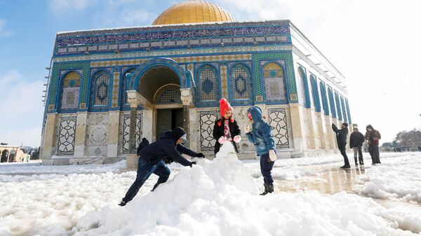 Дети строят снеговика перед мечетью Купол Скалы, расположенной в Старом городе Иерусалима - Sputnik Mundo