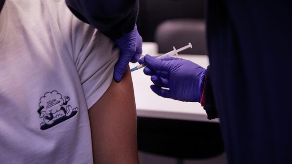 Una persona recibe una tercera dosis de la vacuna contra el coronavirus. Madrid, 3 febrero 2022 - Sputnik Mundo