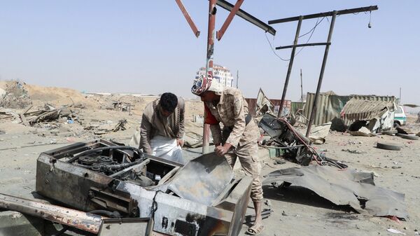 Un hombre y un soldado inspeccionan los daños en una gasolinera afectada por un ataque aéreo liderado por Arabia Saudí en Saada, Yemen, el 26 de marzo de 2022 - Sputnik Mundo