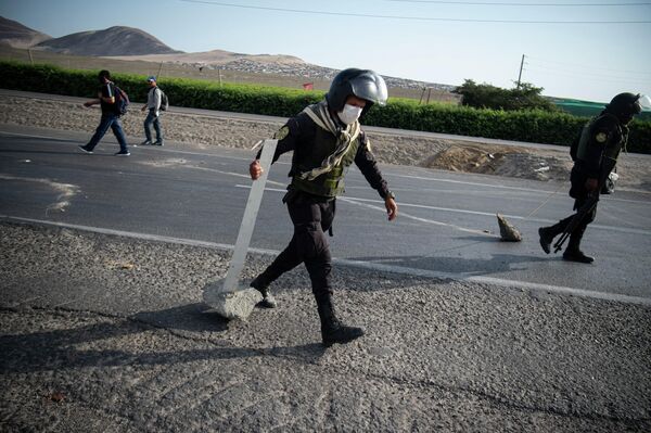 Agentes de policía desbloquean un tramo de la carretera Panamericana en la ciudad de Ica tras dispersar a los manifestantes. Agentes de policía desbloquean un tramo de la carretera Panamericana en la ciudad de Ica tras dispersar a los manifestantes. - Sputnik Mundo