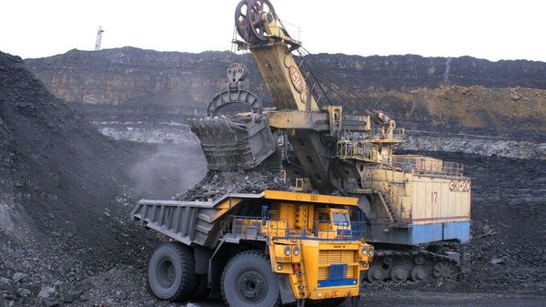 Una máquina carga un camión con carbón en una mina (imagen referencial) - Sputnik Mundo