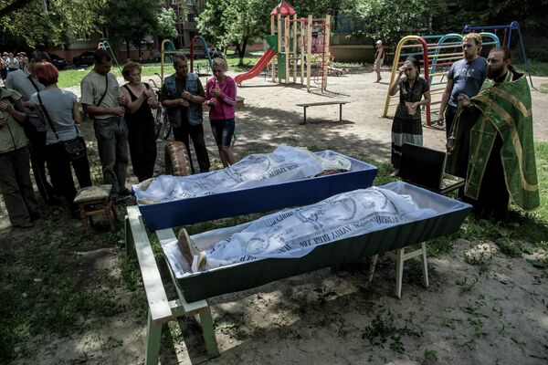 29 de junio de 2014. Se celebra un servicio fúnebre en el patio de un edificio residencial por los muertos durante el bombardeo del barrio de Artióm en Slaviansk, región de Donetsk. - Sputnik Mundo