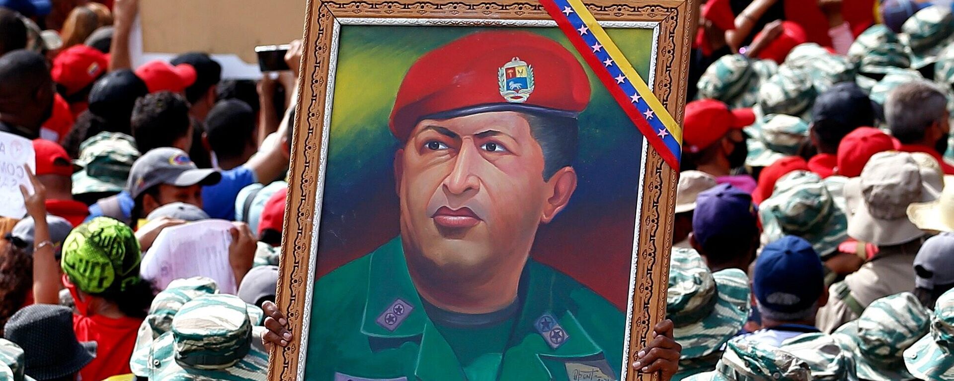 Miliciana porta un cuadro con la imagen de Hugo Chávez durante el Día de la Milicia Nacional Bolivariana - Sputnik Mundo, 1920, 14.04.2022