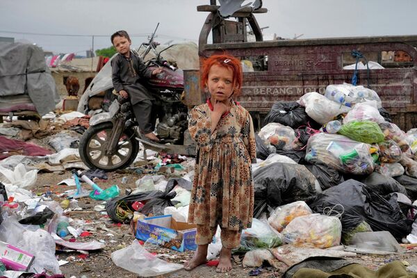 Dos niños afganos en medio de la basura amontonada cerca de su casa, en la ciudad de Kabul. - Sputnik Mundo