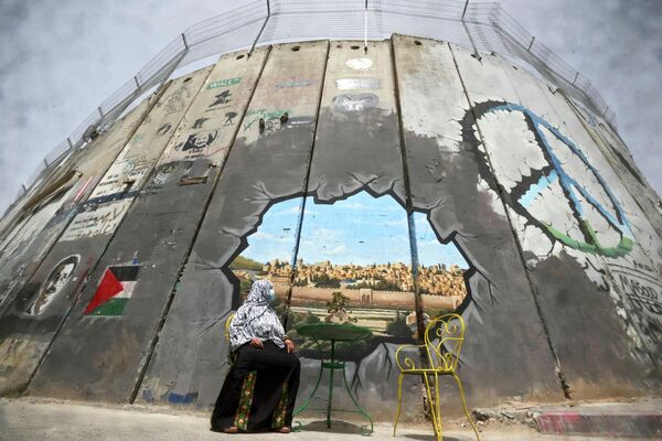 Una mujer palestina observa un mural que representa el complejo de la Mezquita de Al-Aqsa y la ciudad vieja de Jerusalén en la controvertida barrera de separación de Israel entre Jerusalén y la Cisjordania ocupada, en la ciudad de Belén. - Sputnik Mundo