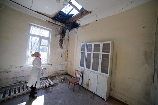 El 11 de febrero de 2015, un proyectil de las Fuerzas Armadas ucranianas alcanzó el hospital nº20 de Donetsk, según informó el servicio de prensa del Ministerio de Emergencias de la República Popular de Donetsk. Una enfermera y siete personas del departamento de neurología sufrieron heridas de metralla. Un hombre que caminaba por un puente cercano al hospital en el momento del bombardeo murió.En la foto: Una empleada del hospital inspecciona los daños del edificio tras el bombardeo de las Fuerzas Armadas de Ucrania. - Sputnik Mundo