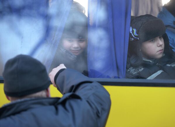 Miles de personas, especialmente mujeres y niños, se vieron obligadas a evacuar a regiones rusas debido a los bombardeos.En la foto: Un padre se despide de su hijo que sale de Donetsk hacia Rusia con otros refugiados. - Sputnik Mundo