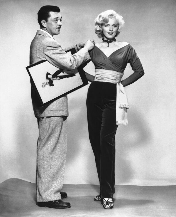 En diciembre de 1950, Marilyn firmó un contrato de siete años con 20th Century Fox. Finalmente comenzó a obtener papeles protagónicos, pero en su mayoría eran papeles de rubias tontas. Sin embargo, su carrera fue cobrando impulso, y en 1953, tras el estreno de las películas Niagara y Gentlemen Prefer Blondes, se convirtió en uno de los principales símbolos sexuales y la actriz más rentable de Hollywood. Ese mismo año, su fotografía salió en la portada de la primera edición de la revista para adultos Playboy. En la foto: Marilyn Monroe probándose un vestido en el set de Gentlemen Prefer Blondes, 1953. - Sputnik Mundo