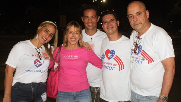 Medea Benjamín, líder de la organización estadounidense Code Pink (con camisa rosada), y el cubanoamericano Carlos Lazo, coordinador de Puentes de Amor (derecha) - Sputnik Mundo