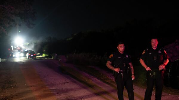 Сотрудники экстренных служб рядом с фурой, в которой были обнаружены тела мигрантов в Техасе - Sputnik Mundo