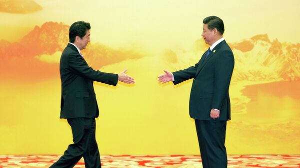 Премьер-министр Японии Синдзо Абэ протягивает руку для рукопожатия председателю КНР Си Цзиньпину  - Sputnik Mundo