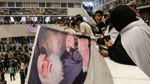  Los partidarios de Muqtada Sadr llevan un retrato del padre de Sadr, el ayatolá Mohammed Sadeq Sadr, en el interior del parlamento iraquí en la Zona Verde de alta seguridad de la capital, Bagdad, el 31 de julio de 2022, un día después de irrumpir en él. - Sputnik Mundo