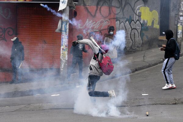 Un manifestante lanza un bote de gas lacrimógeno a los policías durante las protestas de los cocaleros en La Paz, Bolivia. - Sputnik Mundo