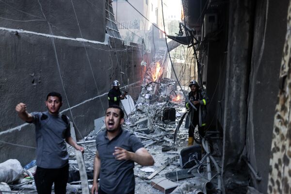 Los rescatistas y los bomberos en la ciudad de Gaza tras un ataque con misiles israelíes. - Sputnik Mundo