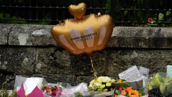 El balón en forma de la corona cerca de la ofrenda floral tras la muerte de la reina británica Isabel II - Sputnik Mundo