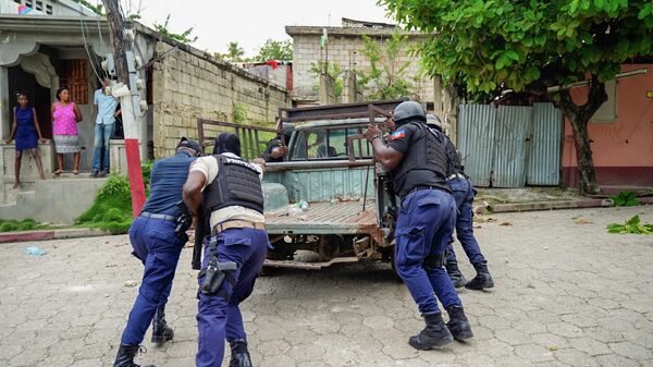 Policía de Haití mueve un vehículo usado en una barricada - Sputnik Mundo