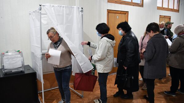 Люди голосуют на референдуме о присоединении Запорожской области к России на избирательном участке на Мелитопольском предприятии - Sputnik Mundo