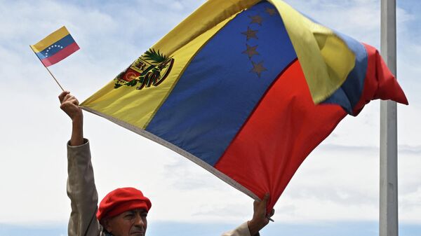 Un hombre levanta la bandera de Venezuela en la ceremonia de reapertura de la frontera con Colombia - Sputnik Mundo