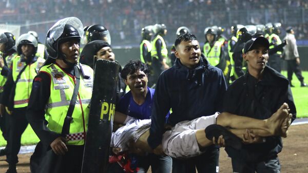 Un hombre herido tras los enfrentamientos durante un partido de fútbol en el estadio de Malang, Indonesia - Sputnik Mundo