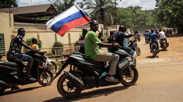 Partidarios del capitán Ibrahim Traore desfilan agitando una bandera rusa en las calles de Uagadugú, Burkina Faso, el domingo 2 de octubre de 2022.  - Sputnik Mundo